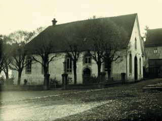 Schwarz-weiß-Bild vom Synagogengebäude, an dem mehrere Bäume stehen