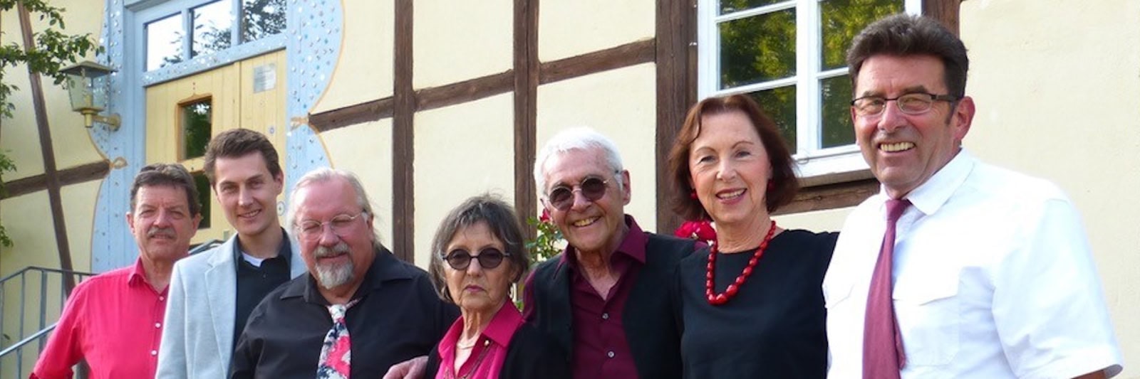 Sieben Musikerinnen und Musiker der Gruppe "Colours of Life" stehen vor einer Hauswand