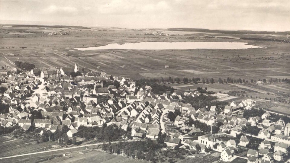 historisches Luftbild in Schwarz-weiß der Stadt Bad Buchau mit Federsee im Hintergrund
