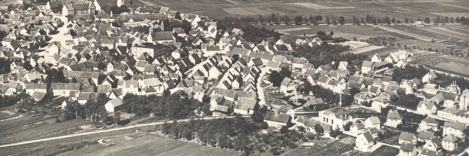 historisches Luftbild in Schwarz-weiß der Stadt Bad Buchau mit Federsee im Hintergrund