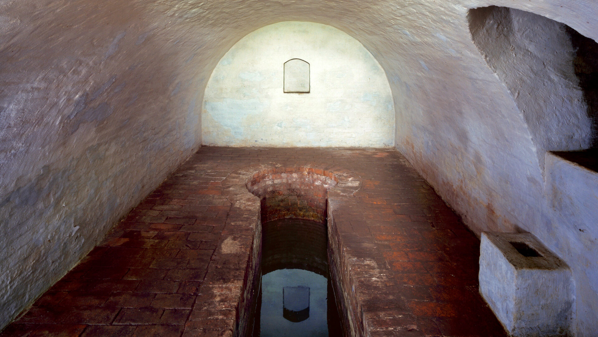 Mikwe Wörlitz: Wasser in der Mikwe in einem runden geweißelten Kellerraum